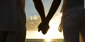 A stock photo of a couple holding hands.